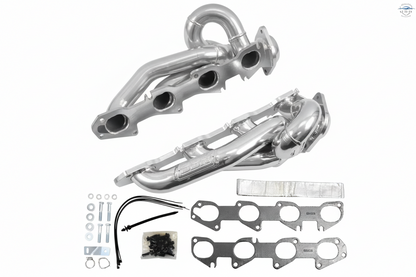 Metallic exhaust manifold set with gaskets and bolts on a white background
